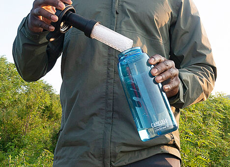 Man carrying water bottle with filter visible. 