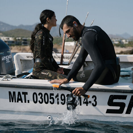 Cram and friends on a boat with wet suits on, ready to get in the water.