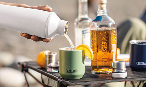 Cocktail shaker pouring a drink in to a rocks glass