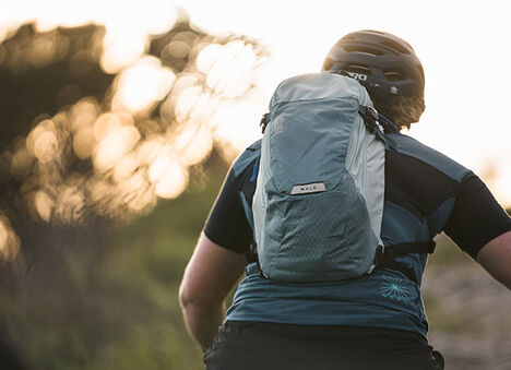 Woman mountain biker wearing a mule hydration pack. Woman mountain biker wearing a mule hydration pack.