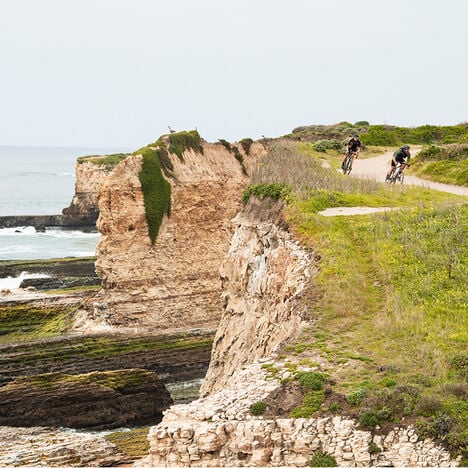 Riders on a trail by a cliff