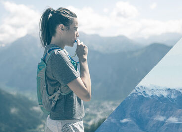 Woman pausing on her run to take a drink from her Circuit vest.