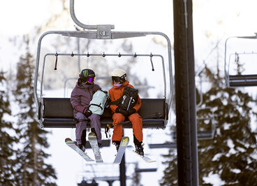 Friends going up a ski lift together.