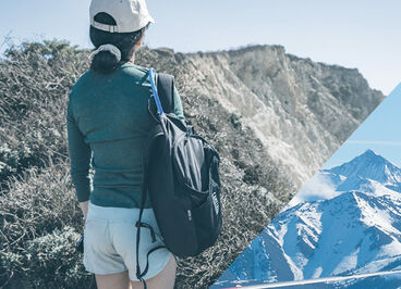 Woman admiring the view of the ocean on a hike with her Arete 14 hydration pack.