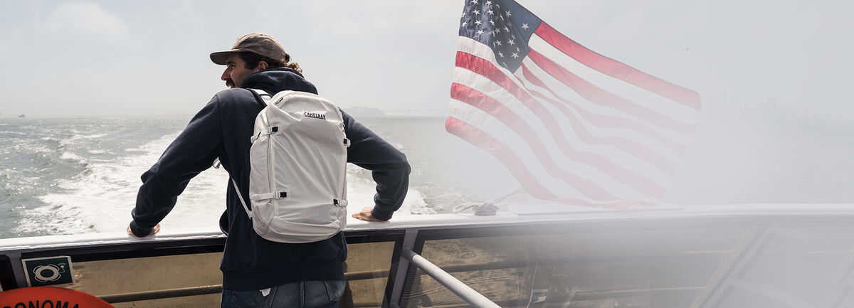 Guy on the back of a boat with an ATP on and an American Flag to the right.