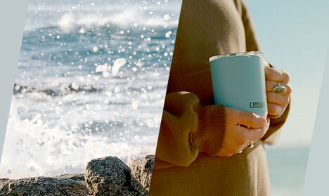 Woman holding a Dusk Blue Camp Mug with waves crashing on to rocks on the left.
