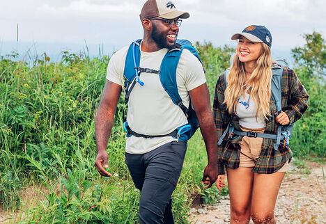 Two hikers talking while going up a trail.
