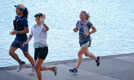 Three runners enjoying themselves while one is waving.