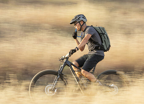 Man using a hydration pack on a bike. Man using a hydration pack on a bike.