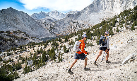 Two hikers going up a mountain with Octane hiking hydration packs on.
