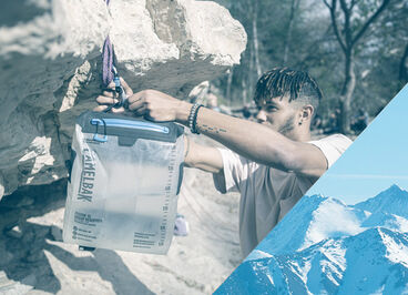 Man hanging up his Fusion Group Reservoir on a rock.