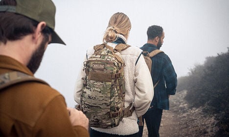 Three people hiking with Mil / LE Hydration Packs