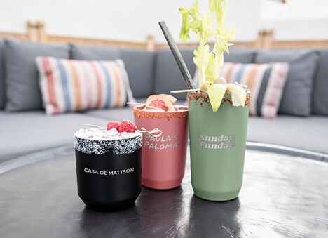 Three custom bottles in a row sitting on a table. Three custom bottles in a row sitting on a table.