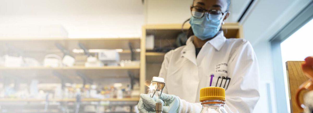 Amy Diallo in a lab making a spark over a bunsen burner.