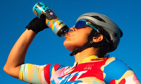 Biker taking a sip from their Podium Sweet Treats donut bottle