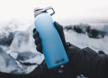 Reusable water bottle with ice in background.