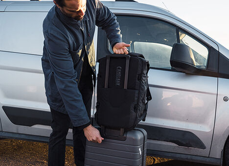 Guy putting his ATP on his roll luggage using the luggage passthrough feature.