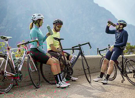 Group of cyclists hydrating with CamelBak bottles Group of cyclists hydrating with CamelBak bottles