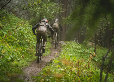 Two people biking on a trail.