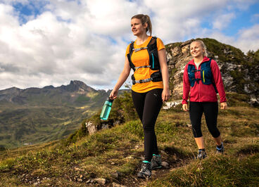 Two Women Hiking and Carrying Water Bottles.