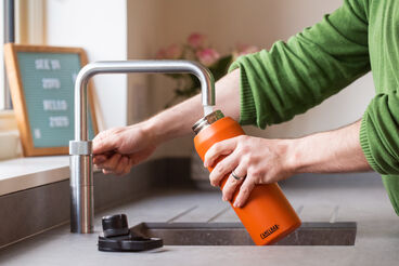 Reusable water bottle being refilled.