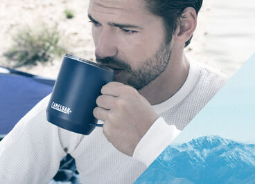 Man sipping from his camp mug in his tent.