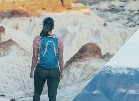 A women hiking in the desert wearing a hydration pack