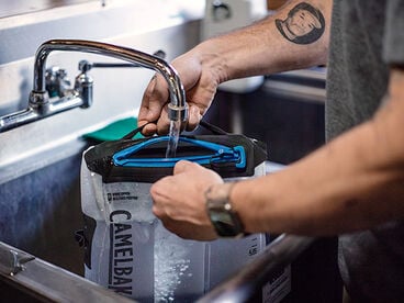 Man filling up a water bottle with a fusion group reservoir