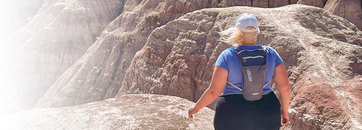 Unlikely Hikers founder Jenny Bruso out hiking wear a CamelBak.