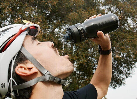 Cyclist drinking from their Podium Steel bottle using its' "no squeeze" feature.