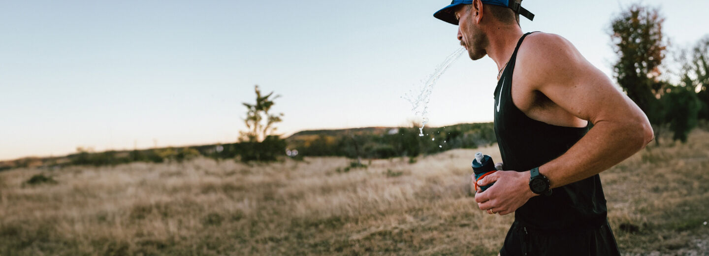 Man running with a water bottle in hand