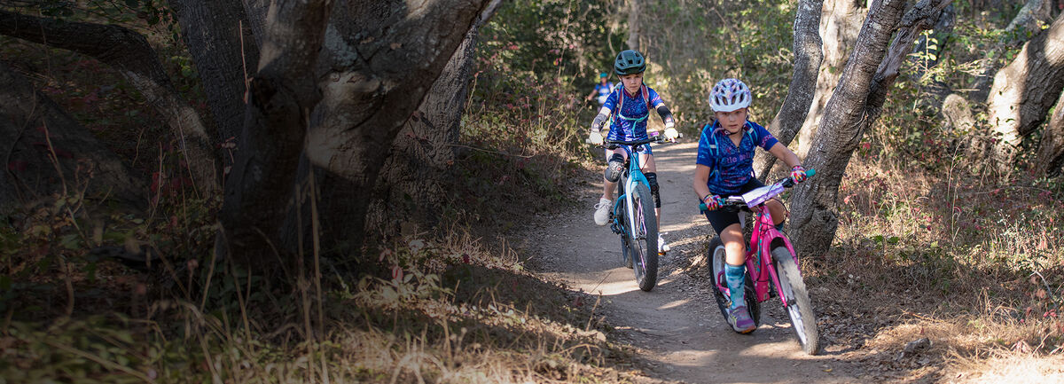 Two little bellas bikers riding on a trail