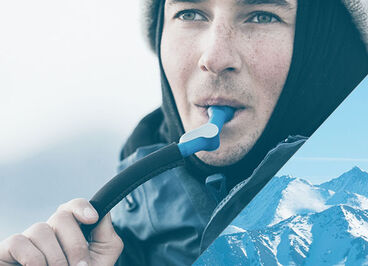 Man drinking from a reservoir with an insulated tube.