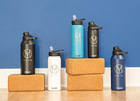 Five custom bottles with yoga blocks on a blue background. Five custom bottles with yoga blocks on a blue background.