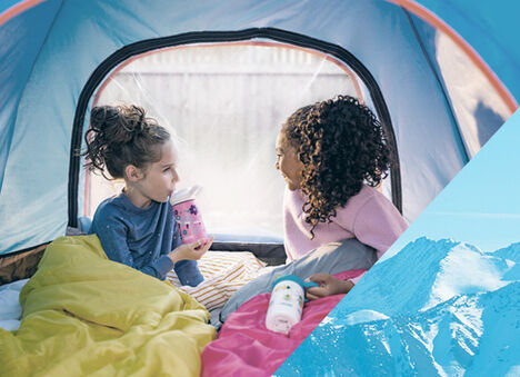 Two girls camping in a tent with their Eddy+ bottles.