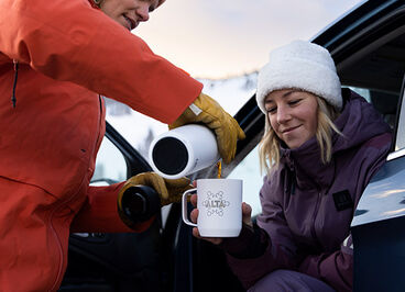 Woman pouring a drink in to a custom Camp Mug