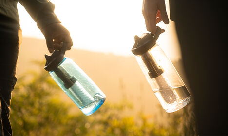 Two people holding CamelBak bottles filtered by Lifestraw Bottles.