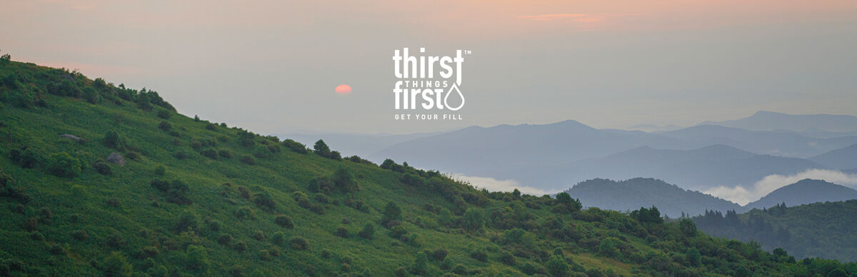 Sky and mountains with thirst things first logo.