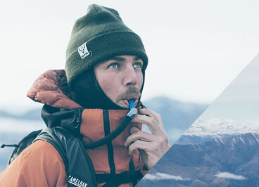 Man drinking out of his Stowaway reservoir in the snow. 