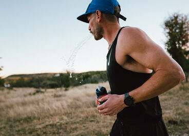 Man running and holding a bottle in his hand