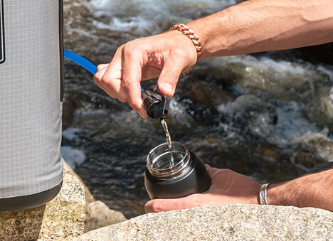 A person filling up their water bottle from the ChillBak cooler.