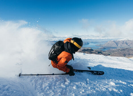Man skiing down a mountain wearing a Camelbak Snowe Hydration Pack Man skiing down a mountain wearing a Camelbak Snowe Hydration Pack