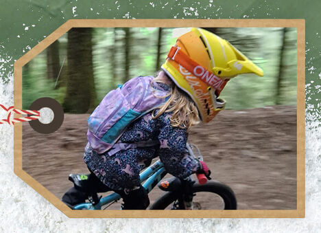 A kid wearing a Mini MULE hydration pack while on their bike.