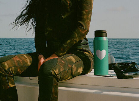 Lagoon colored water bottle sitting on the side of a boat