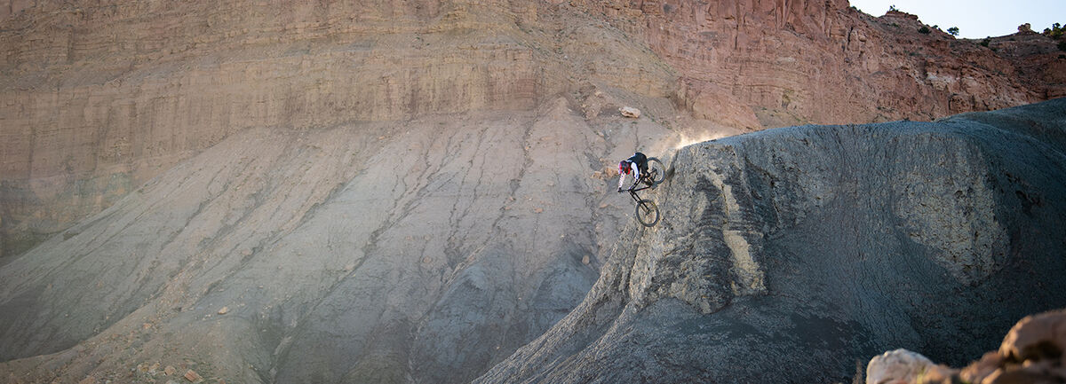 Mountain biker riding down a steep cliff.