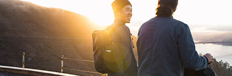 Two people with ATP packs on overlooking a bay