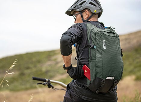 Man using a hydration pack on a bike. 