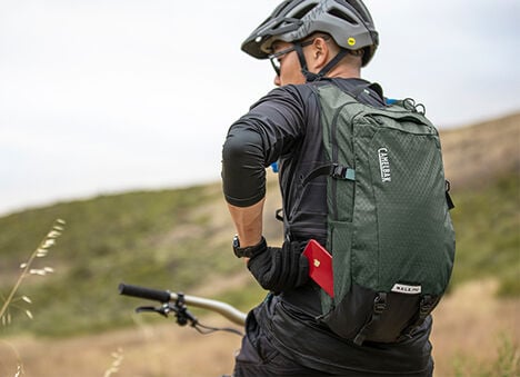 Man using a hydration pack on a bike. Man using a hydration pack on a bike.