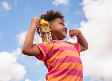 Kid carrying a limited edition Back to School Eddy+ water bottle. Kid carrying a limited edition Back to School Eddy+ water bottle.