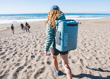 Woman walking at the beach wearing her ChillBak cooler